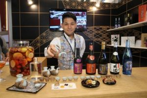 An exhibitor from the Japan pavilion showcases shochu from Okinawa to which seasonal fruits can be added to create a special cocktail.